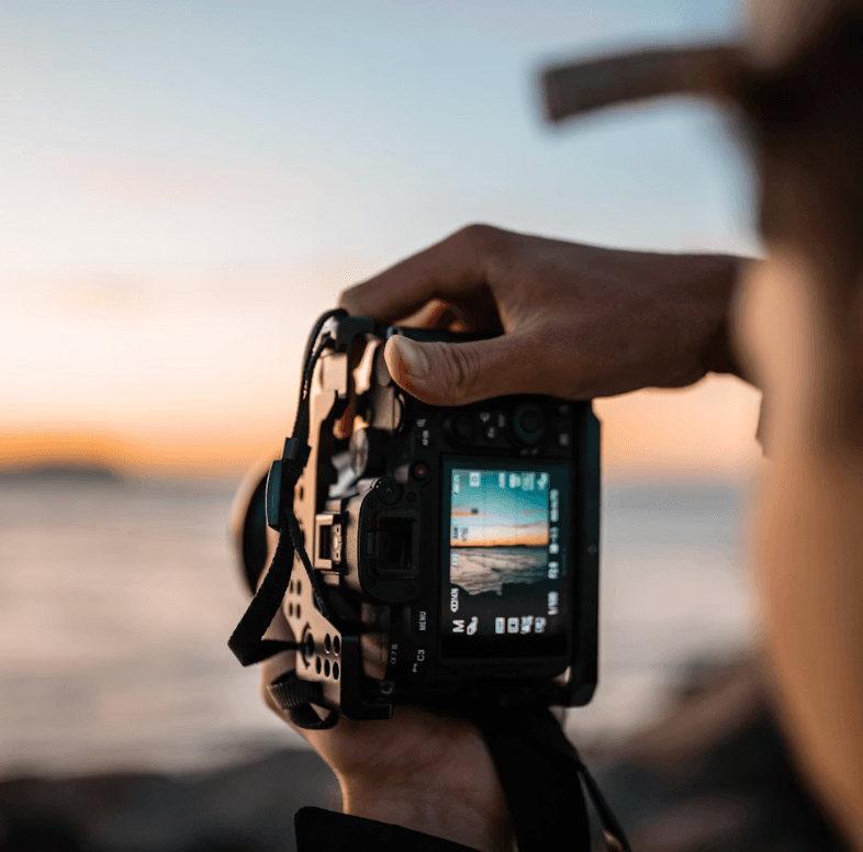 Photographer shooting with a camera at sunset